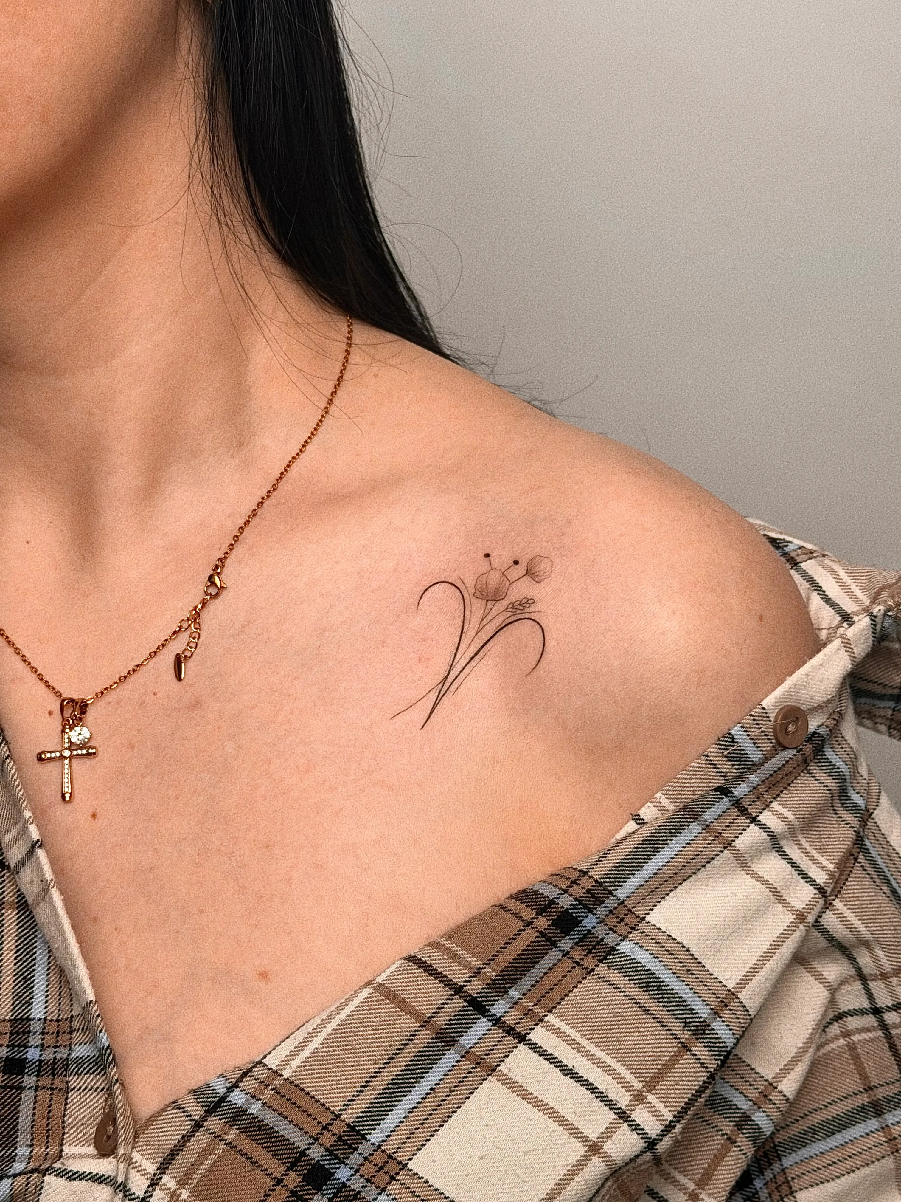 Fijne bloementattoo op de schouder