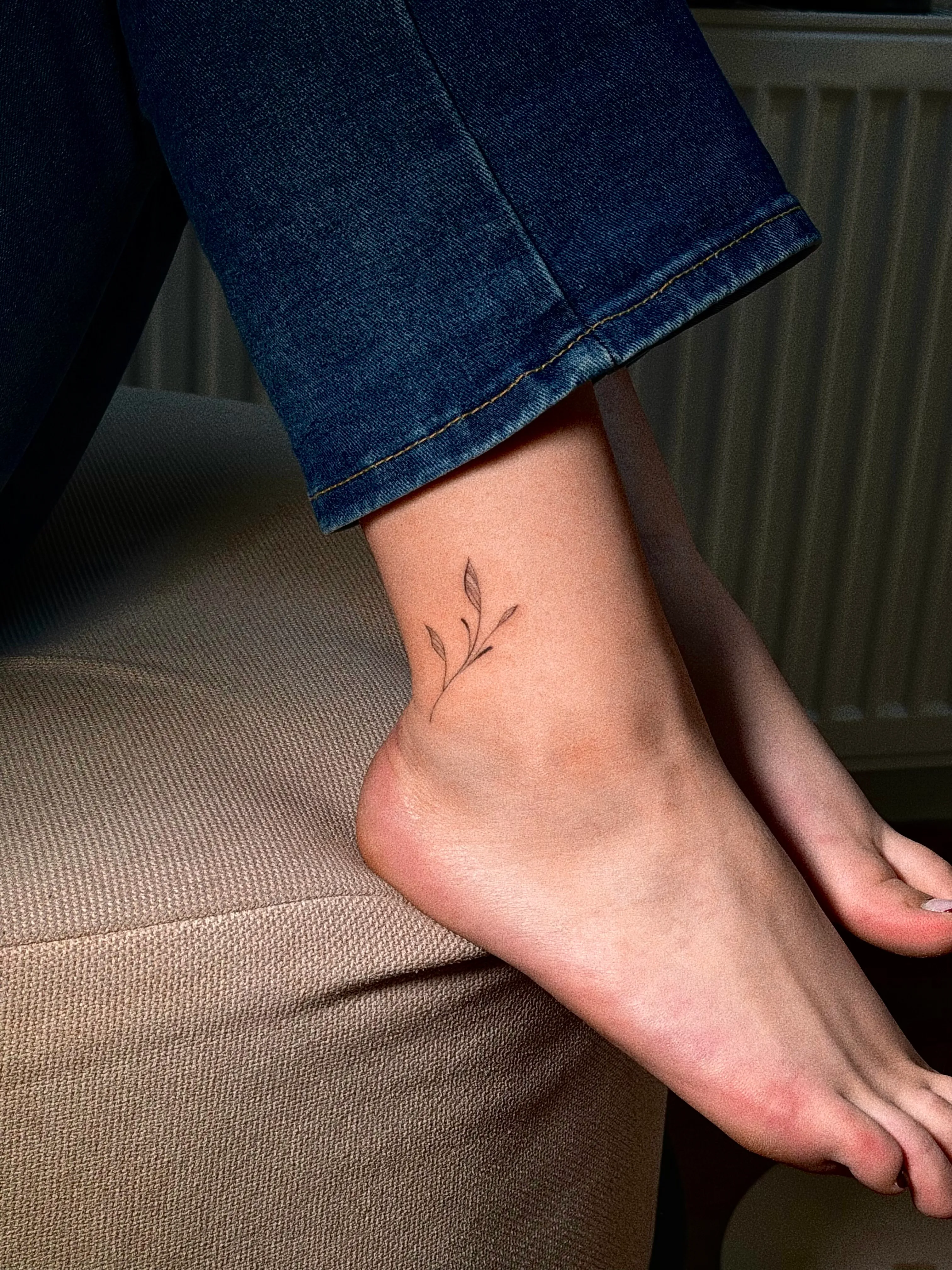 Fine line vine tattoo op de enkel en voet