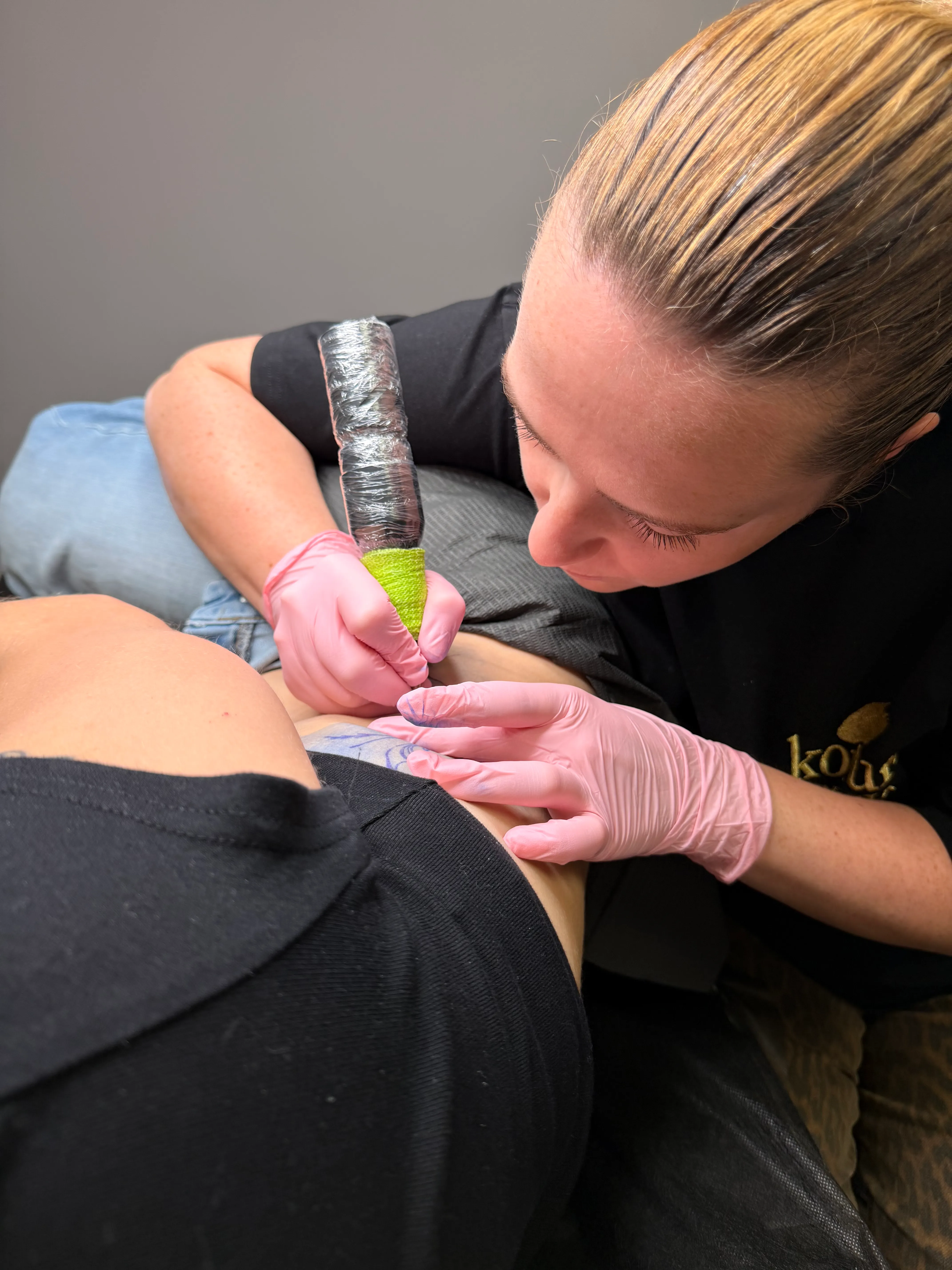 Liliya zet met aandacht een fine line tattoo